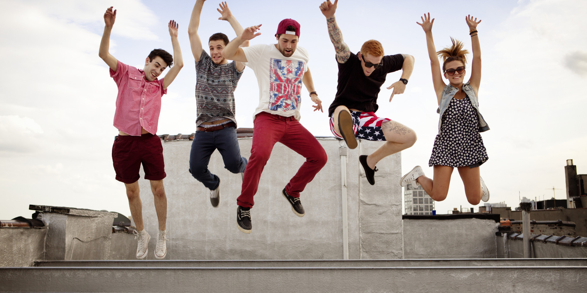 Group Of Friends Jumping Of Beam On Rooftop
