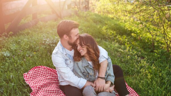 Loving couple cuddling on green meadow