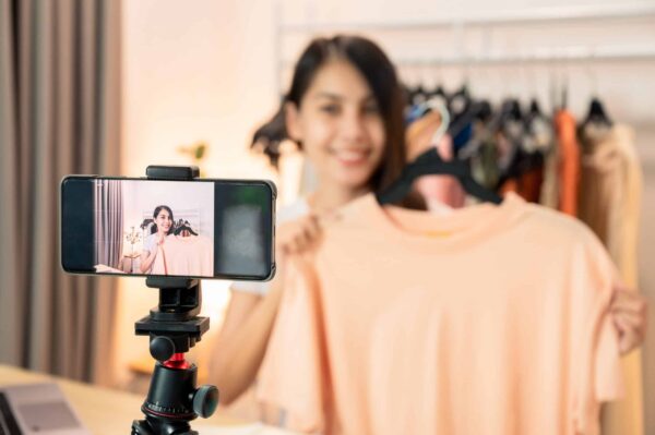 Asian online seller woman selling shirt by smartphone through so