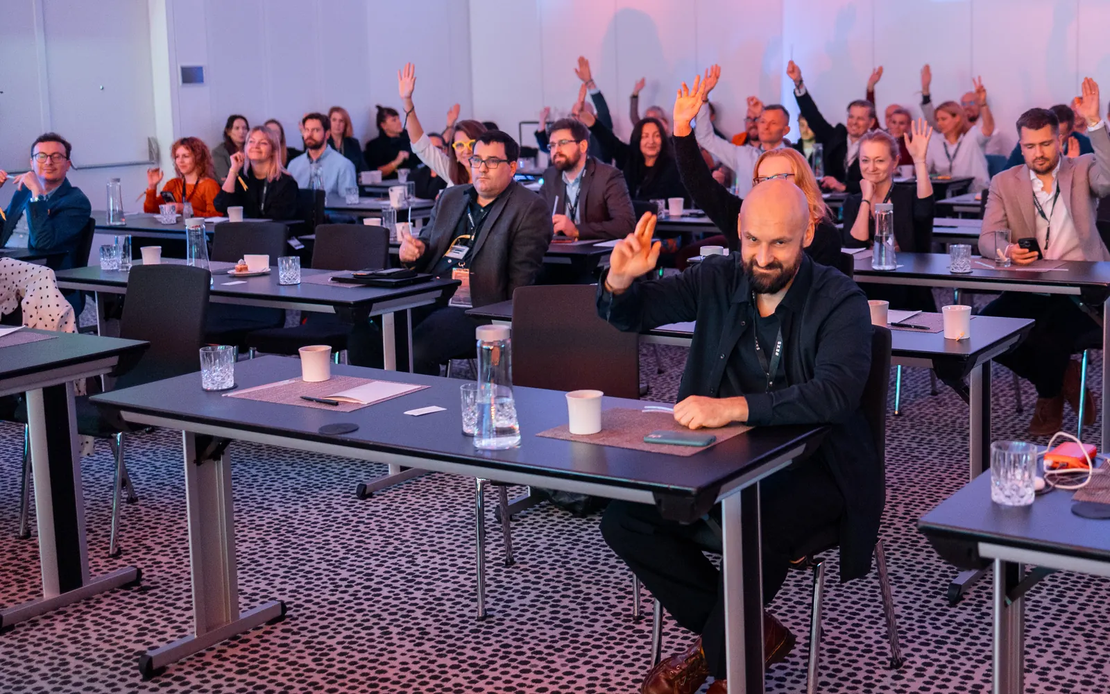 Uczestnicy CMO Executive Summit podnoszą ręce podczas wystąpienia
